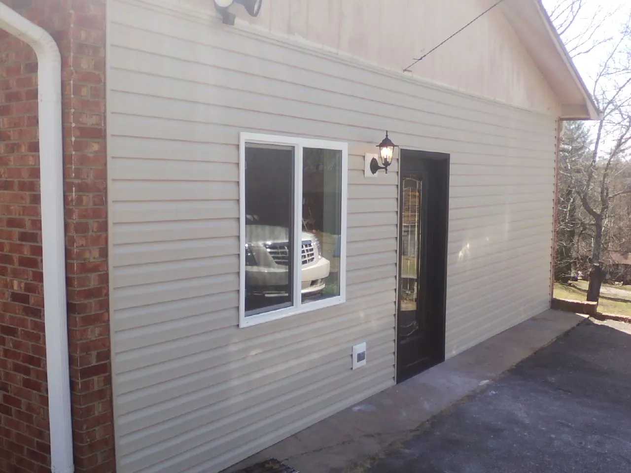 New vinyl siding and entry door on a room addition in Anna